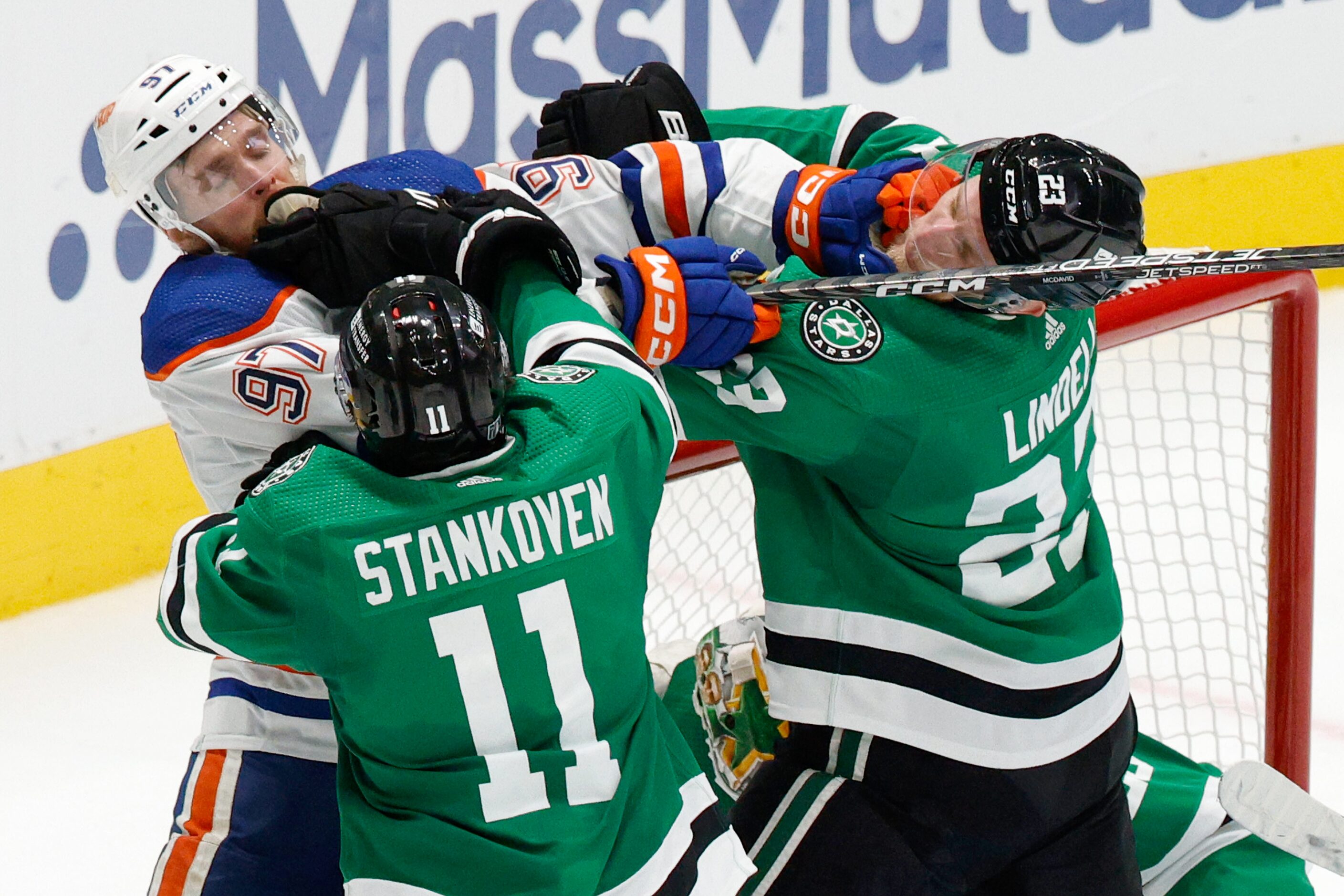 Dallas Stars center Logan Stankoven (11) and defenseman Esa Lindell (23) tussle with...