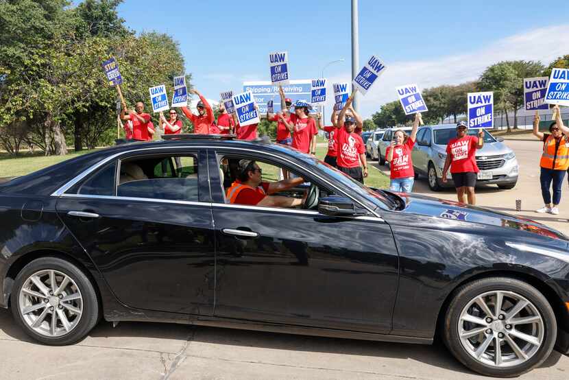 United Auto Workers members cheer as co-workers drive off from their jobs at General Motors’...