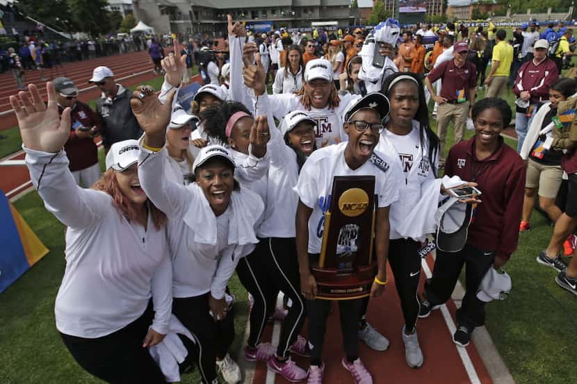Members of the women's Texas A&M's team pose with the trophy after winning the NCAA outdoor...