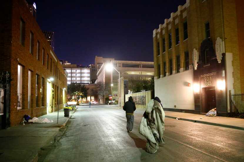 People move their blankets down Park Ave next to The Stewpot on Park Ave in downtown Dallas...