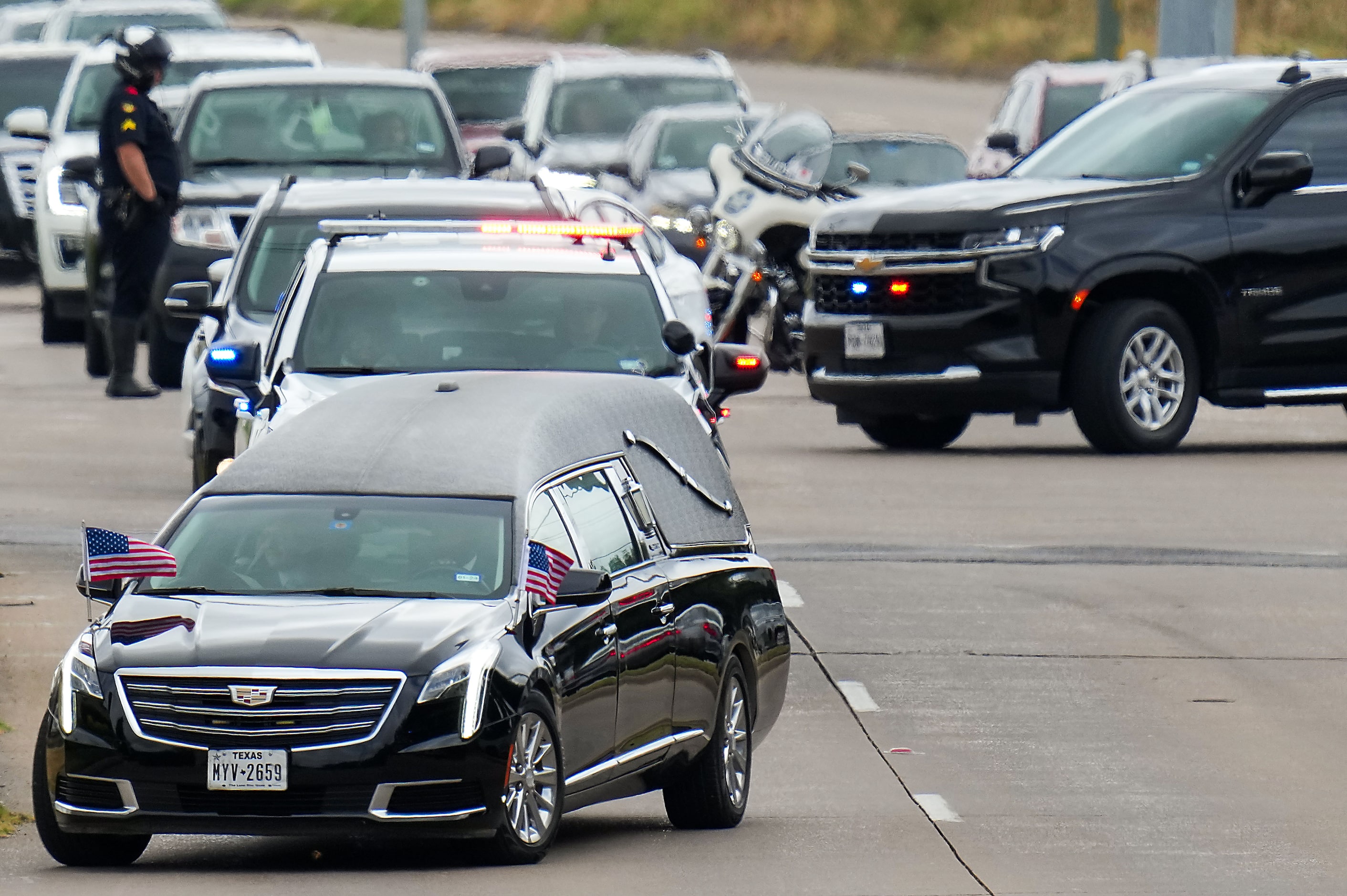 A hearse leads a procession as fallen Dallas Police officer Darron Burks is transferred from...