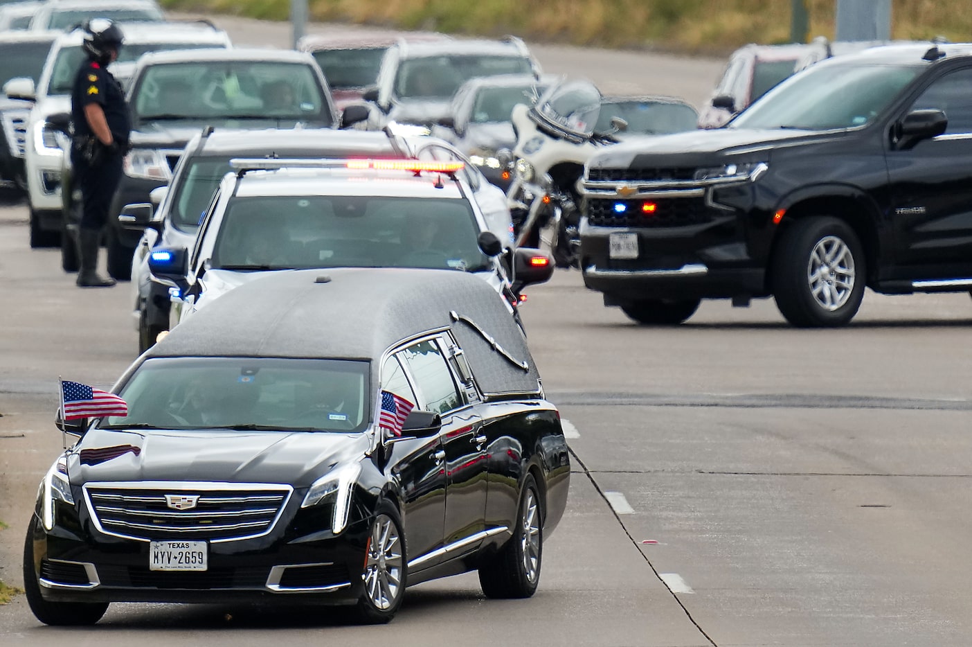 A hearse leads a procession as fallen Dallas Police officer Darron Burks is transferred from...