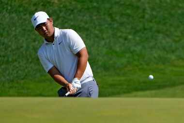 Tom Kim, of South Korea, chips up on the 15th hole during the first round of the Travelers...