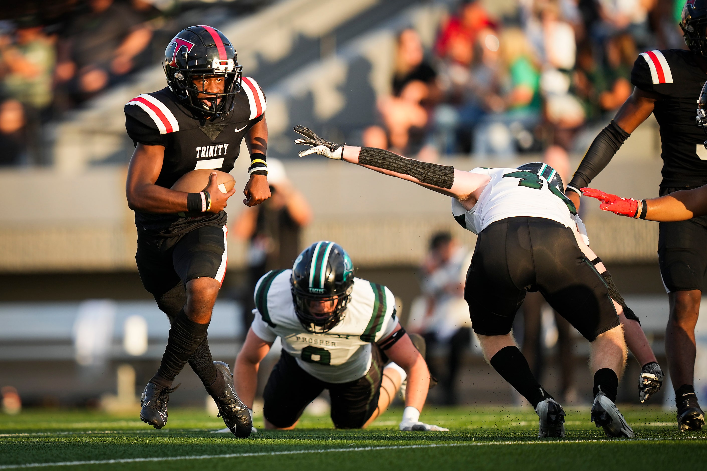 Euless Trinity quarterback Ethan Williams (5) gets past Prosper defender Jackson Forte (40)...