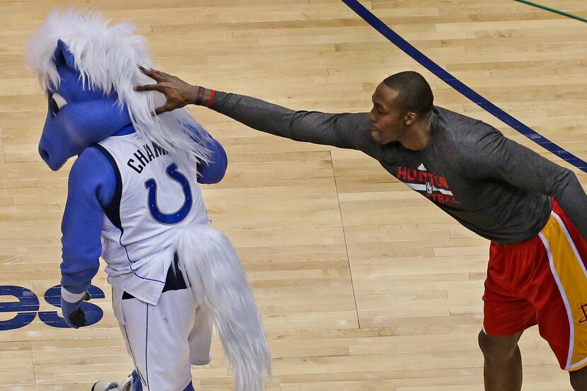 Houston's Dwight Howard playfully pushes "Champ," the Mavericks' mascot, before a Nov. 20...