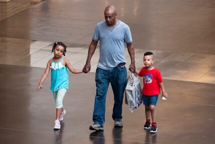 A man walks with his children after shopping at Dillard's inside NorthPark Center in Dallas. 