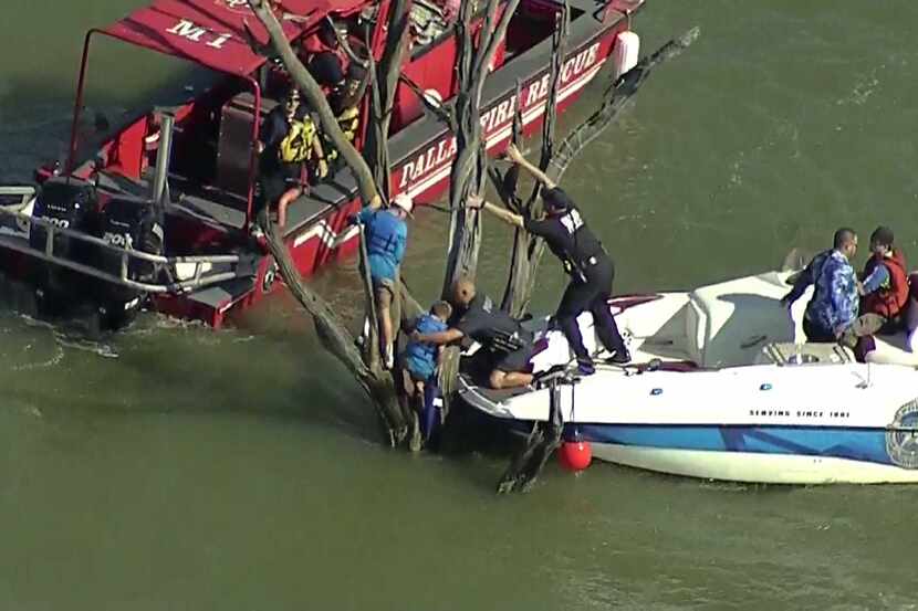 Rescuers from Dallas police and Dallas Fire-Rescue work to free two children stranded in a...