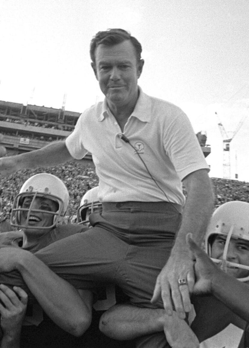 Coach Darrell Royal is carried from the field on the shoulders of Texas players following...