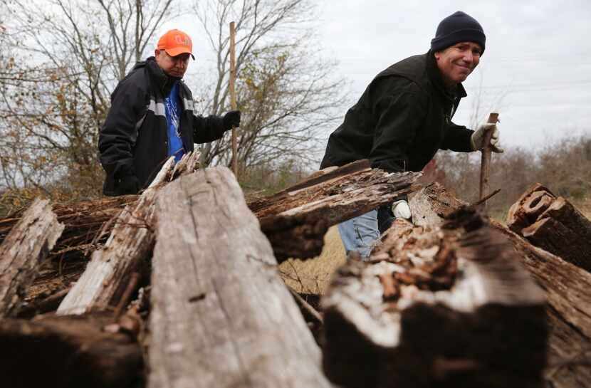 Mark Morris (right) and Clint Jenkins look beneath a pile of wood in northern Collin County...