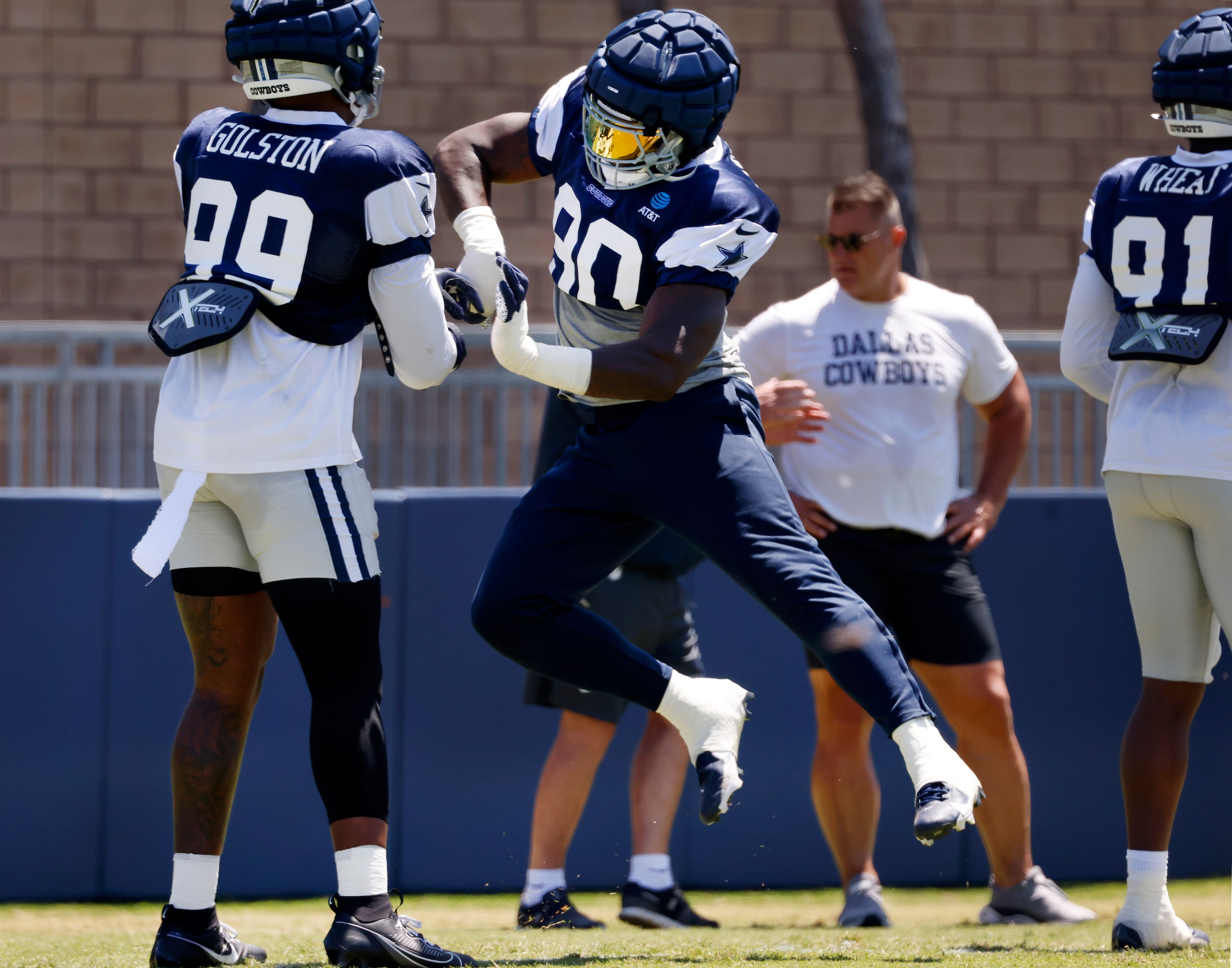 Dallas Cowboys defensive ends DeMarcus Lawrence (90) and Chauncey Golston (99) work on pass...