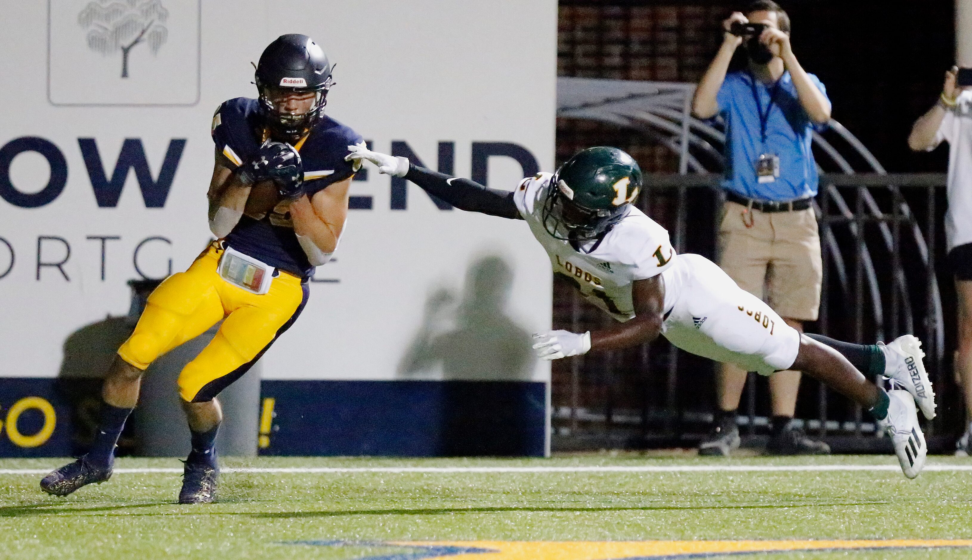 Highland Park High School wide receiver Jackson Heis (85) catches a touchdown pass behind...