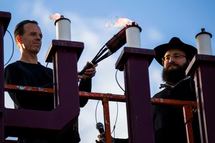 Evan Bundis, left, and Rabbi Moshe Naparstek lighted the largest menorah in Texas on Dec....