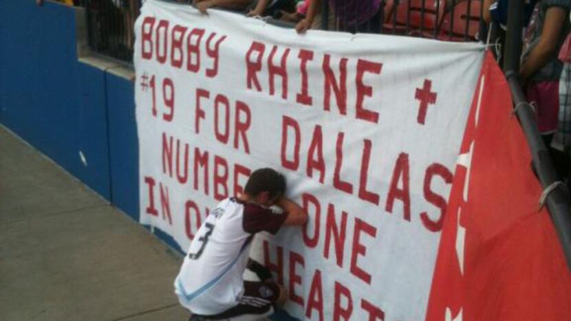 Drew Moor, returning to Dallas for the first time since Bobby Rhine's passing, kneels in...