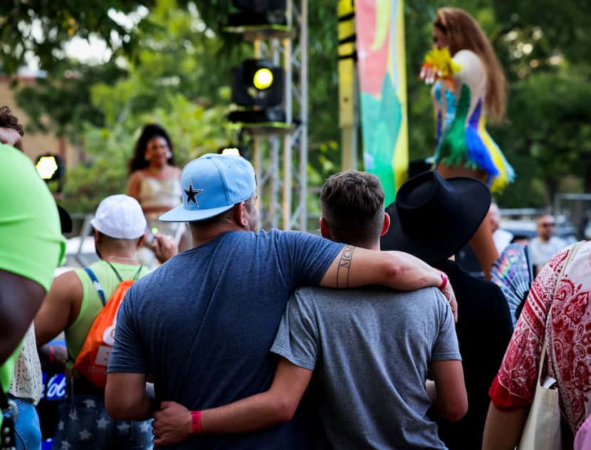 Rudy Enriquez and Dylan Dickinson hug as they watch a drag artist perform on stage during...
