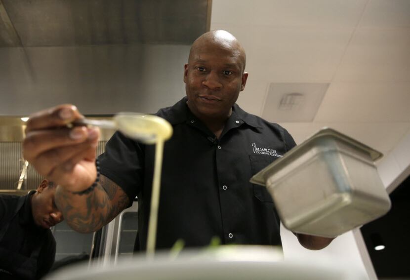 Chef Tre Wilcox drizzles dressing over salad during a cooking demonstration for media and...