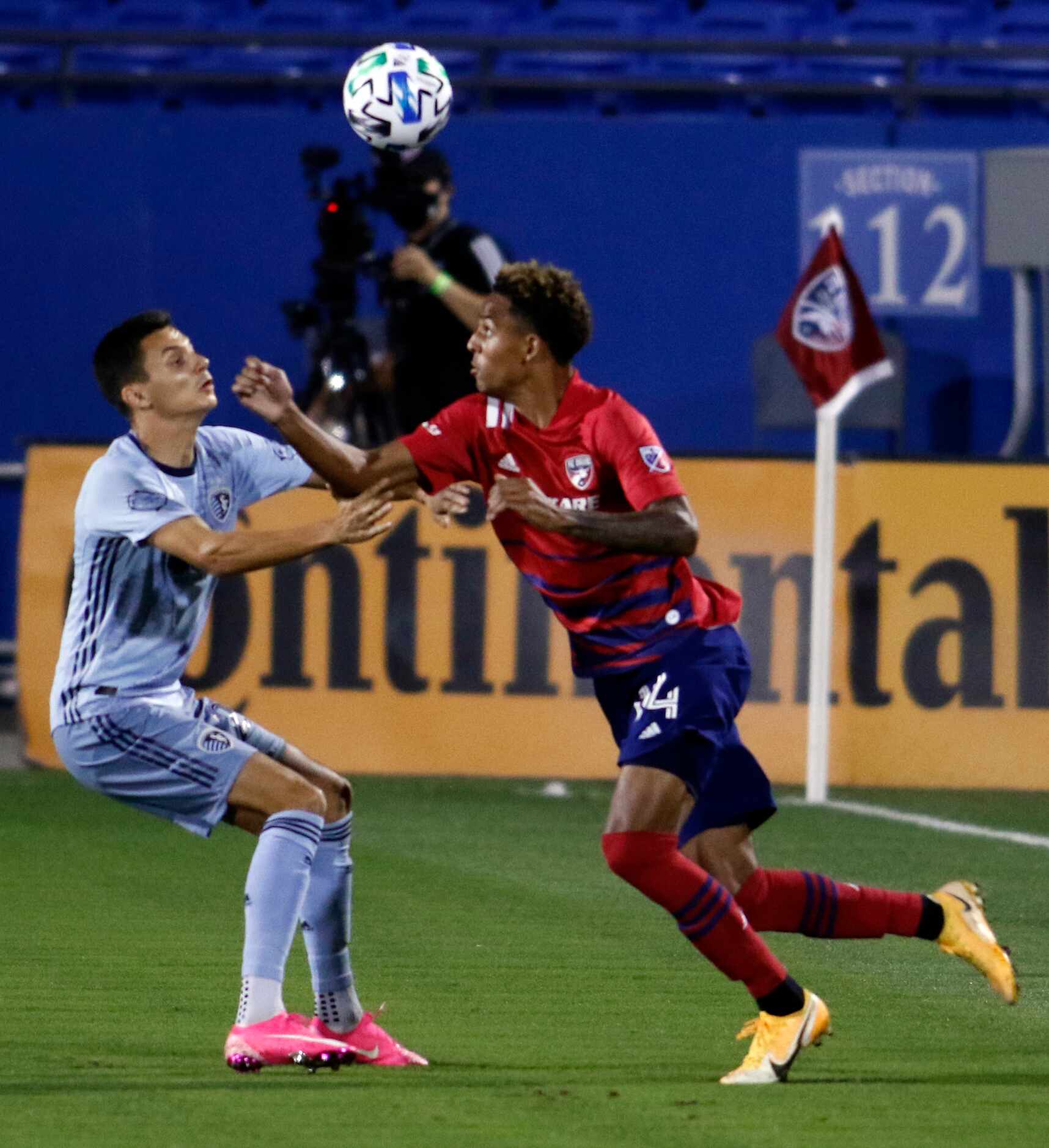 FC Dallas' Bryan Reynolds (14) eyes the ball as he works around the defense of Sporting KC's...