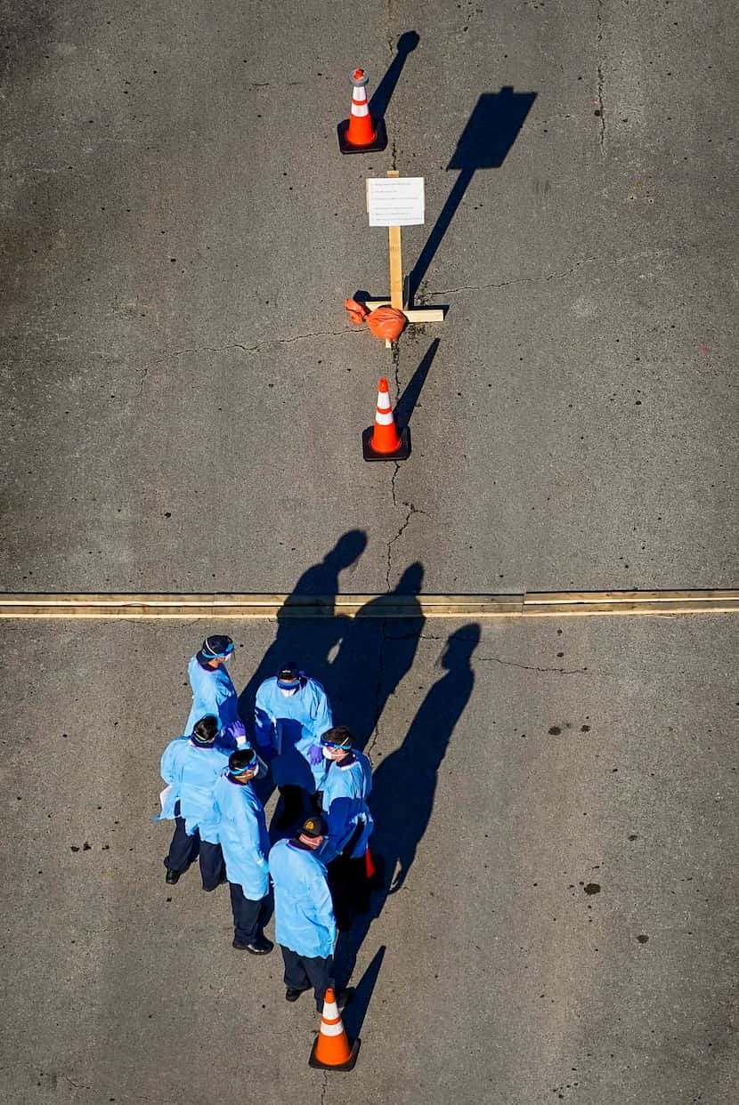 Tuesday afternoon, medical professionals work at a Dallas County drive-thru COVID-19 testing...