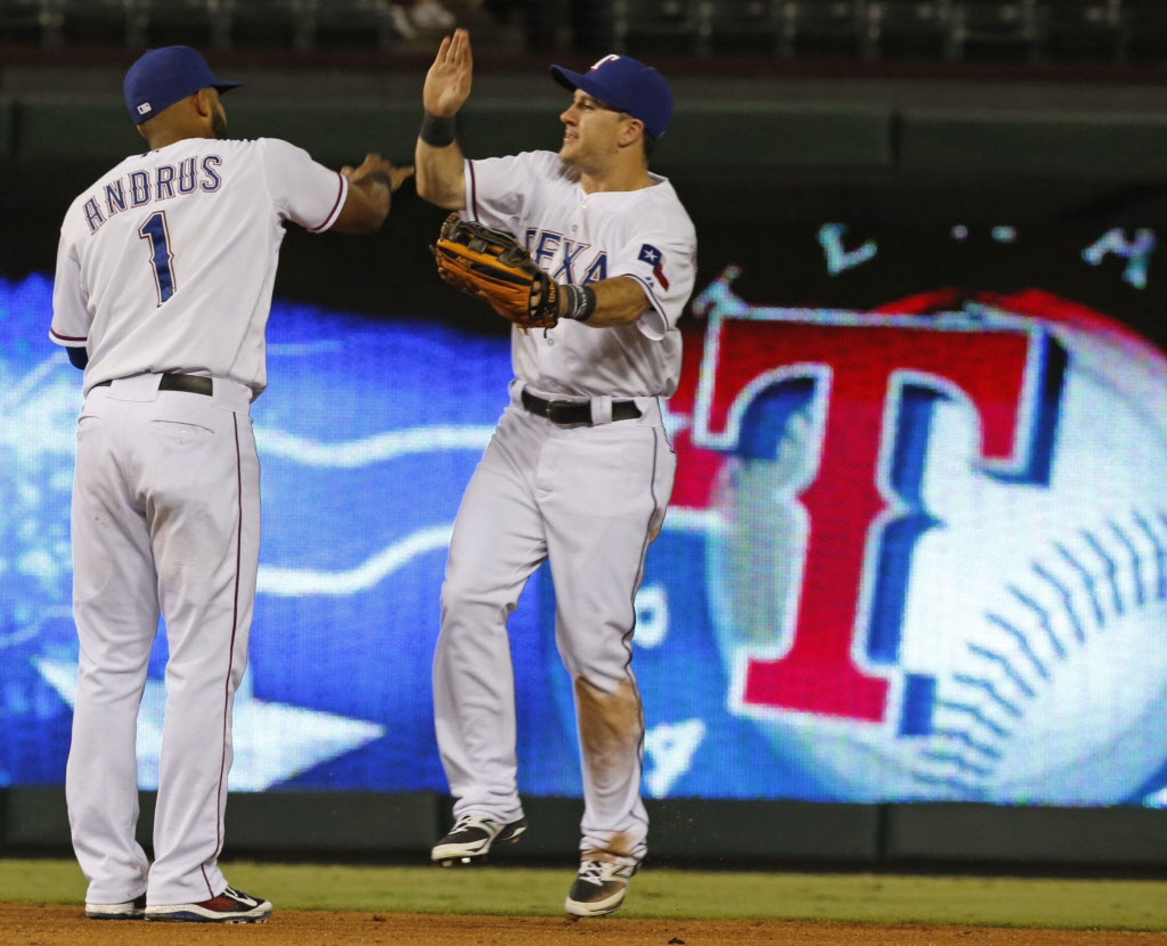 Texas shortstop Elvis Andrus and outfielder Daniel Robertson celebrate after the final out...