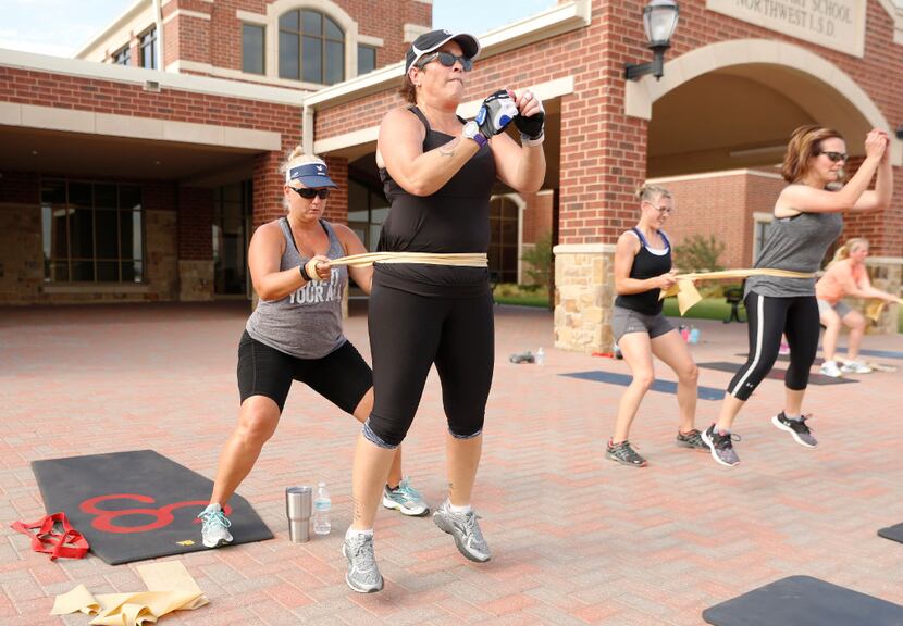 Tina Pearson (left) helps Rhonda-Lee Foulds work out at a Camp Gladiator session in Roanoke....