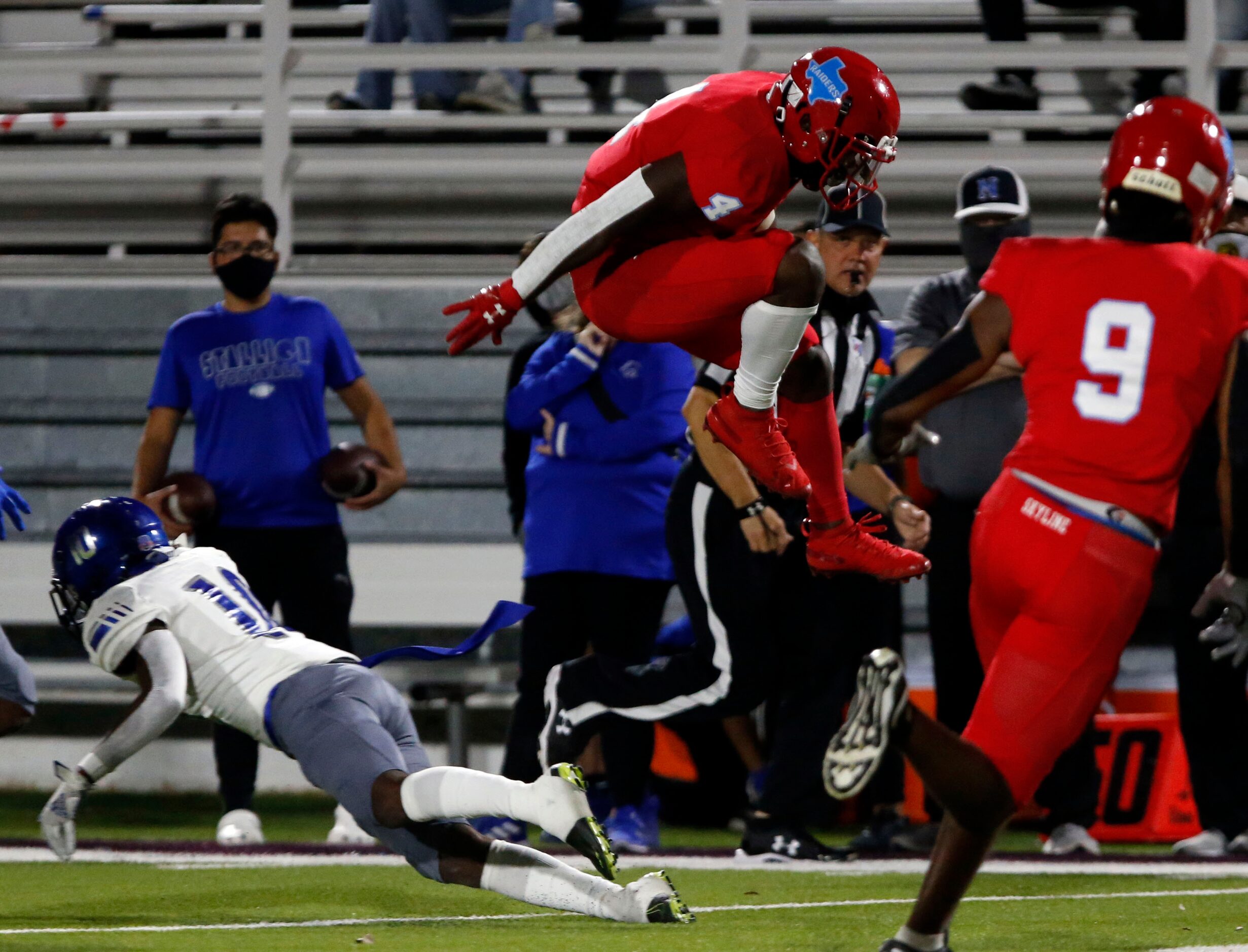 Skyline's Qualon Farrar (4) leaps high to avoid a tackler during the first half of a high...