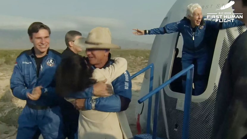 Wally Funk stretches her arms wide as she exits the capsule while Blue Origin founder Jeff...