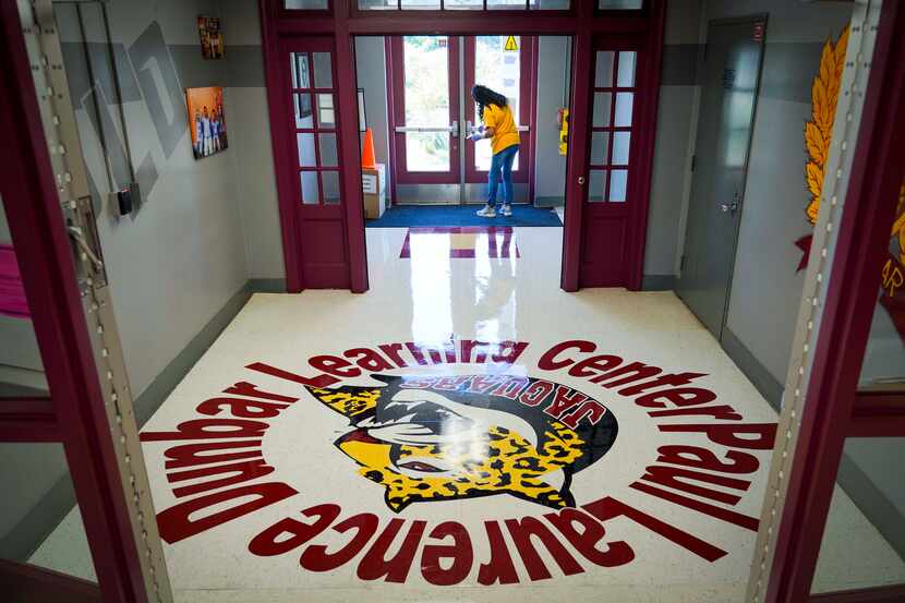 Custodian Debra Booty disinfected high-touch areas recently at Paul L. Dunbar Learning...