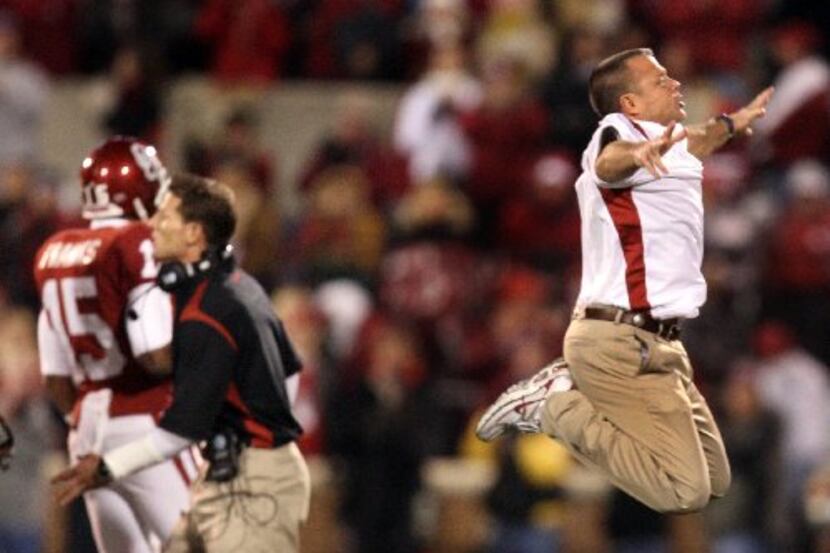 OU director of sports enhancement Jerry Schmidt goes airborne as he reacts to the action on...