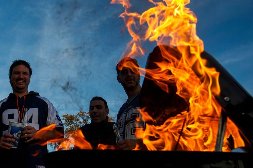 Flames reached high as fans fired up a grill before a game between the Dallas Cowboys and...