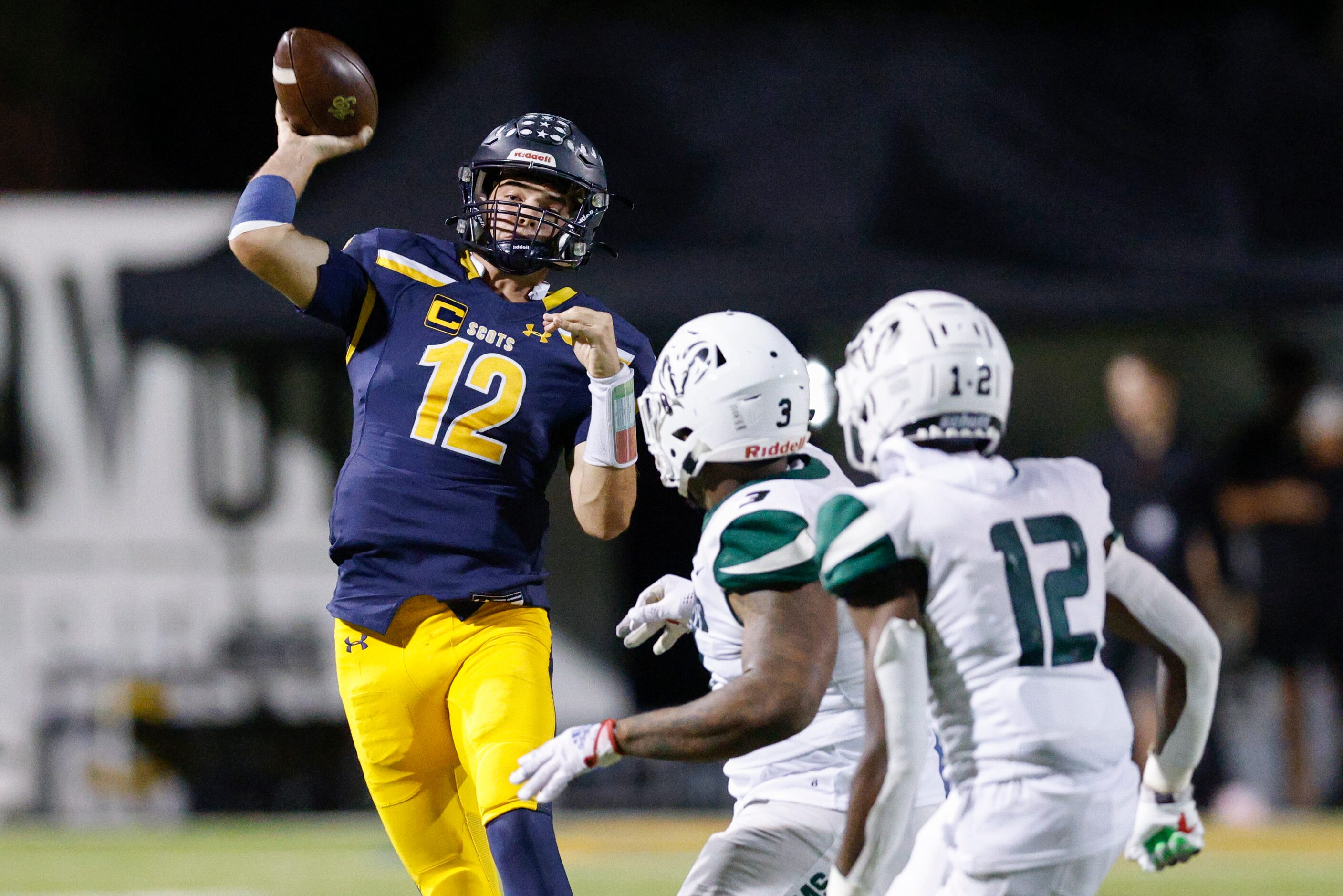 Highland Park quarterback Warren Peck (12) throws a pass under pressure during the second...