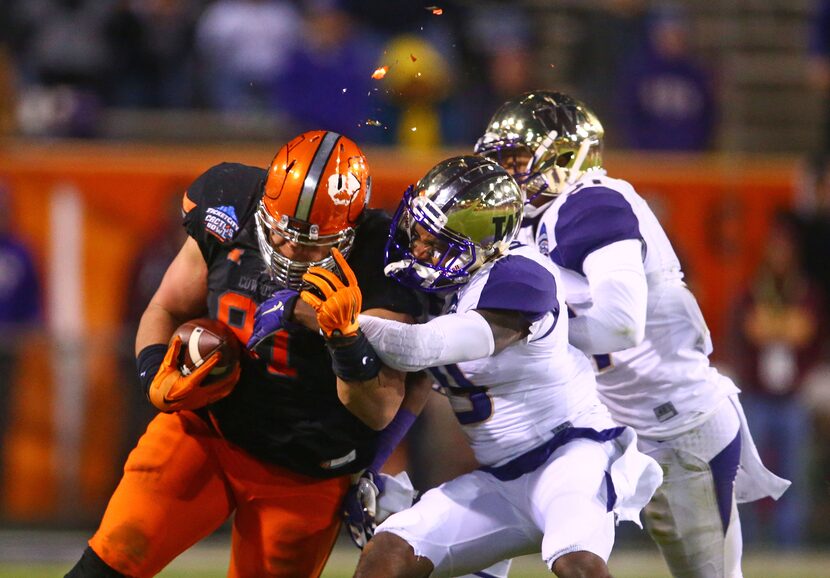  Paint flies from the helmet of Oklahoma State Cowboys defensive tackle James Castleman (91)...