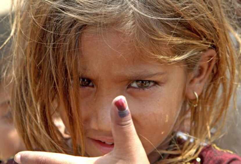 
A Pakistani girl shows her marked thumb, signifying that she has received the polio...