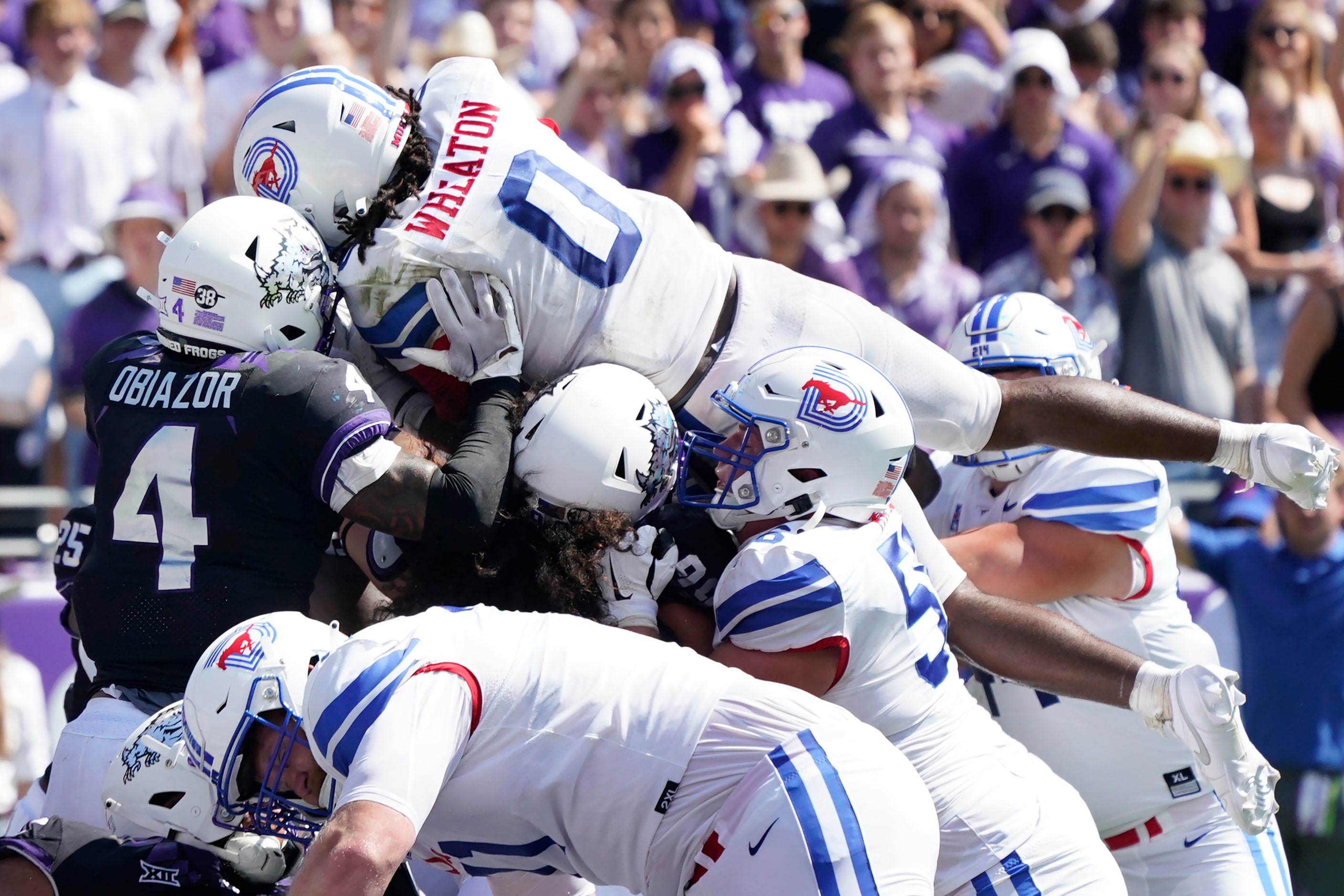 SMU running back Camar Wheaton (0) goes over the top against TCU linebacker Namdi Obiazor...