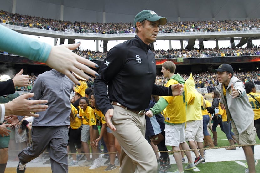 Baylor Bears head coach Art Briles runs through the line during introductions before a game...