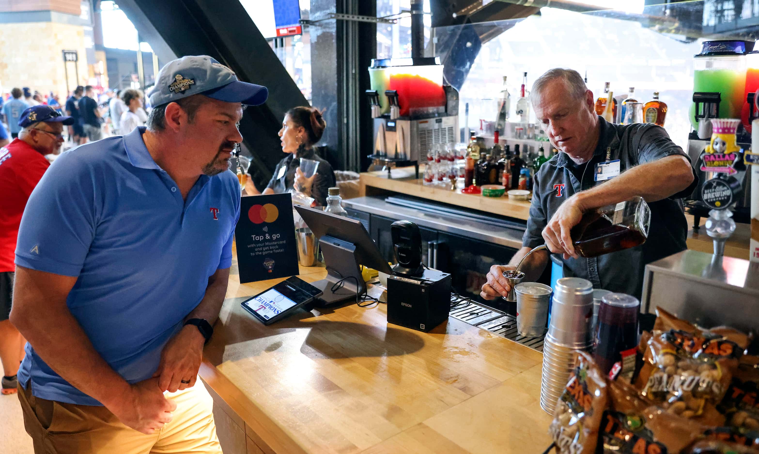 Bartender Stan Mills  (right) prepares a drink for customers ahead of During MLB All-Star...
