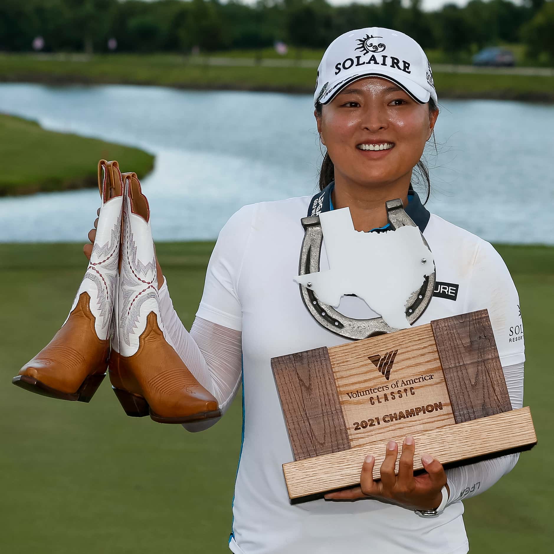 Professional golfer Jin Young Ko holds the winner’s trophy and a pair of Lucchese boots...