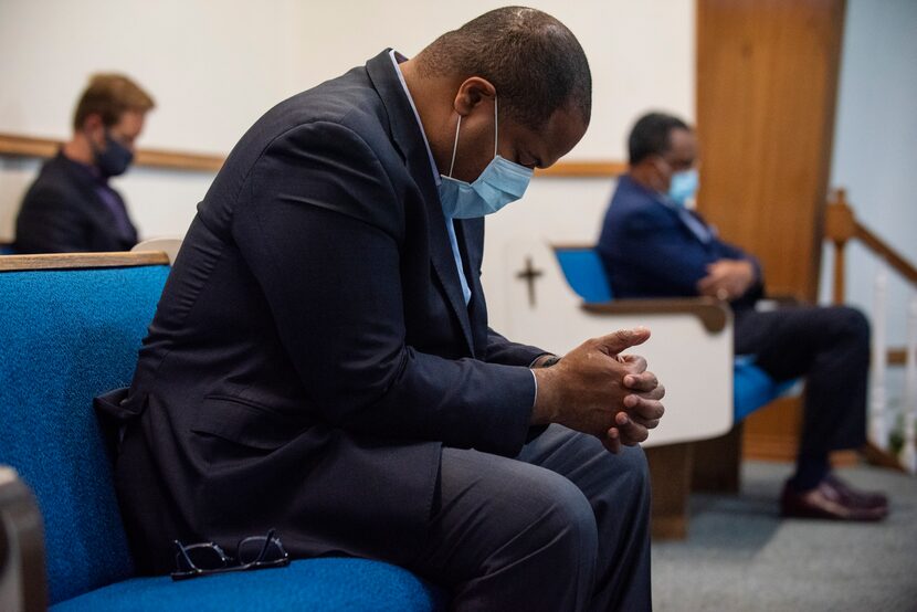 Dallas Mayor Eric Johnson bows his head during a special prayer event with several area...