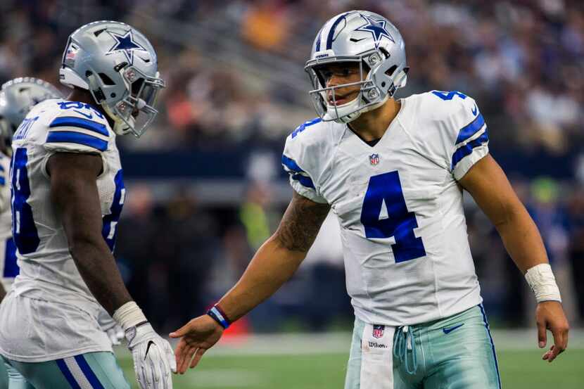 Dallas Cowboys quarterback Dak Prescott (4) high fives wide receiver Dez Bryant (88) during...