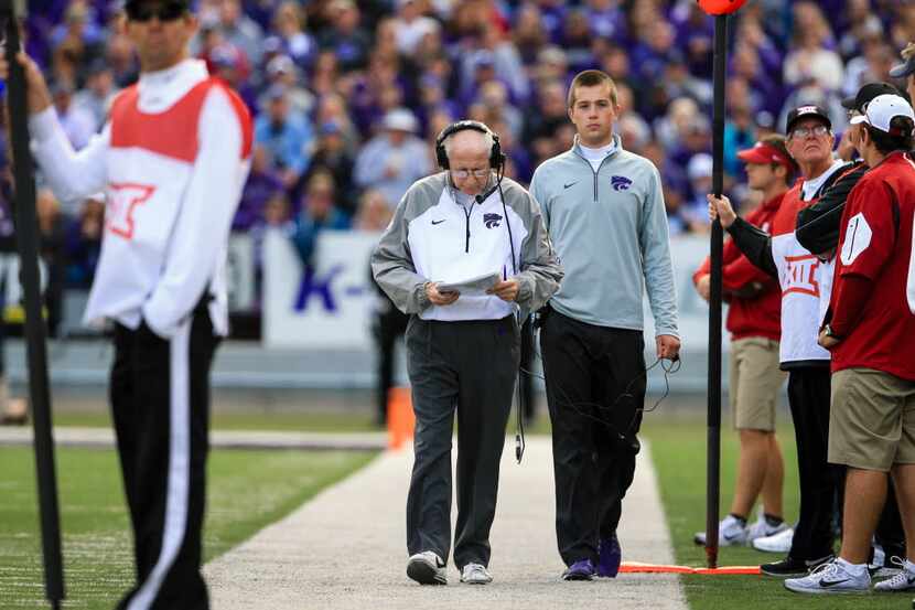 Kansas State head coach Bill Snyder, center left, consults his notes on the sideline during...