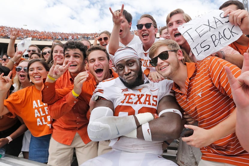 Texas Longhorns defensive lineman Charles Omenihu (90) poses with fans after the Longhorns'...