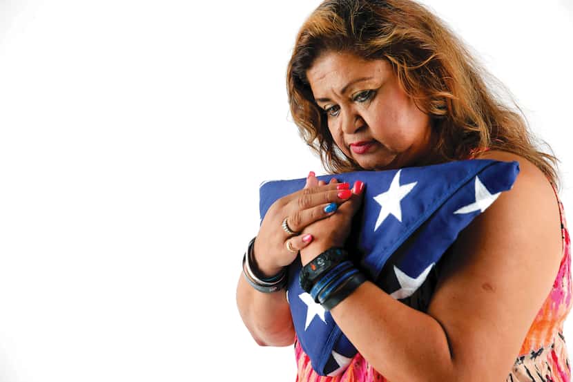 Valerie Zamarripa, mother of Officer Patrick Zamarripa, embraces the American flag she...