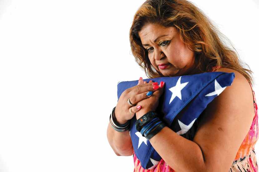 Valerie Zamarripa, mother of Officer Patrick Zamarripa, embraces the American flag she...