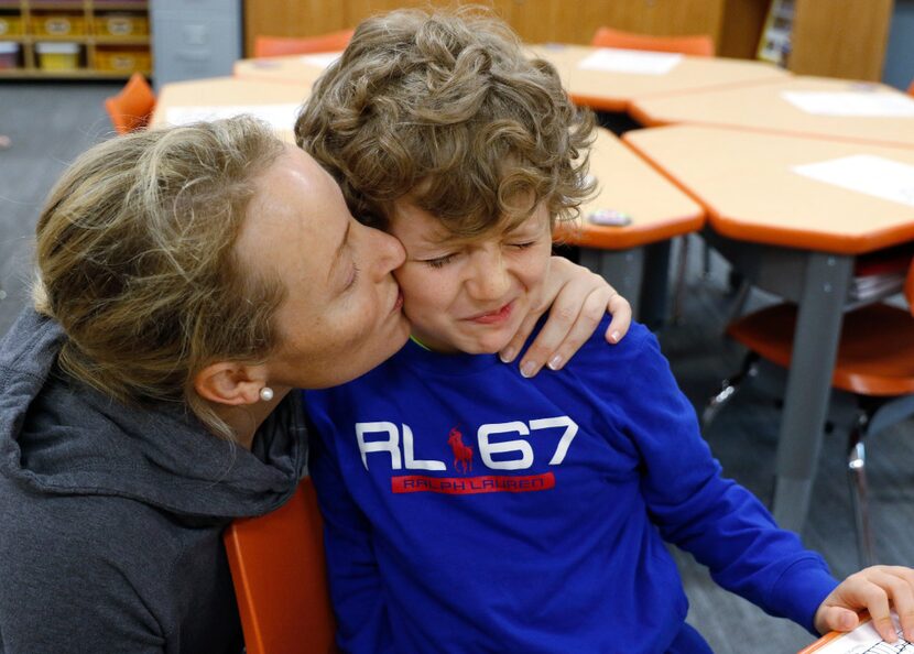 Christina Benedetti gives a goodbye kiss her son, Sebastian Benedetti, 7, as she leaves him...