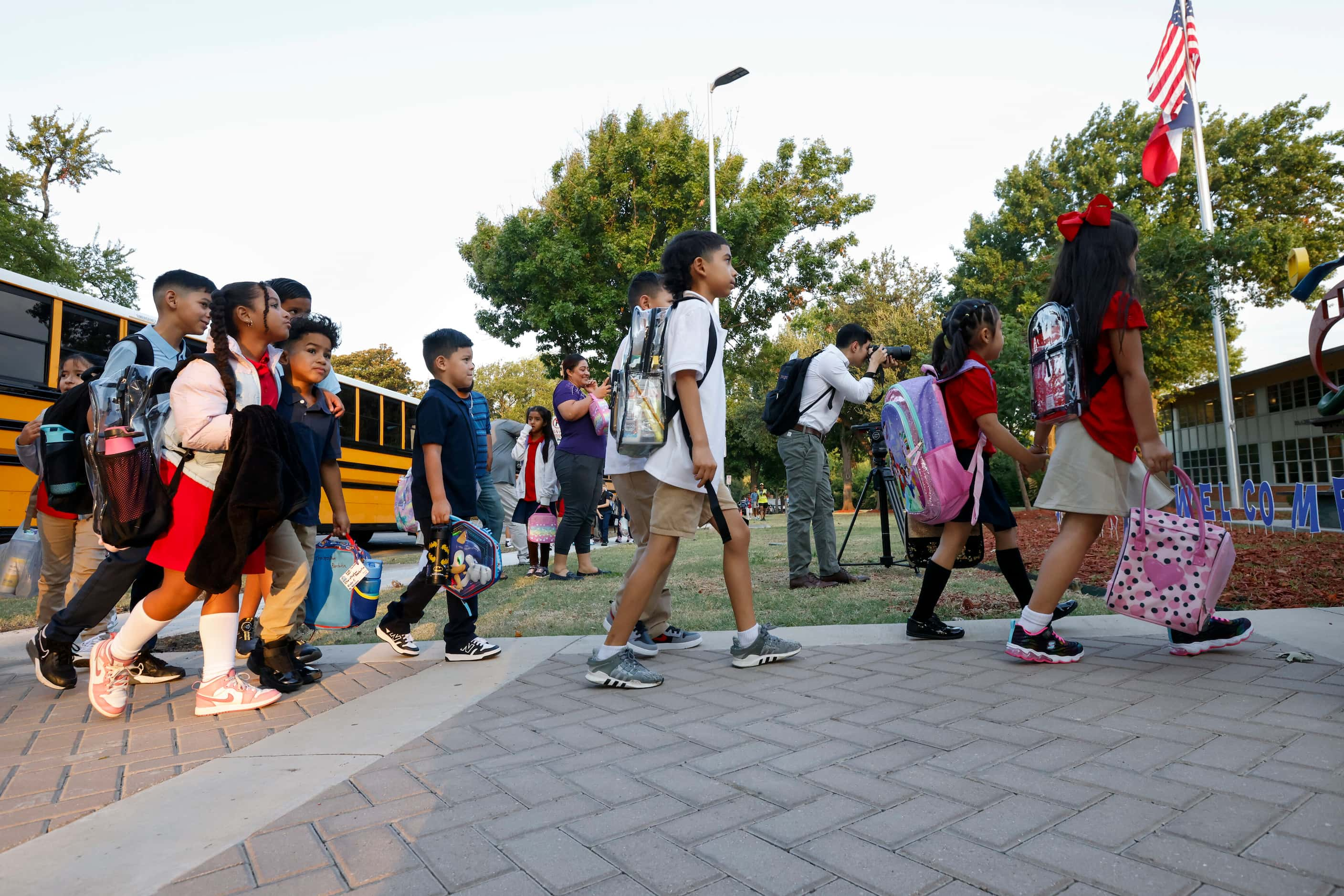 A group of students walk to John J. Pershing Elementary School for the first day of classes,...