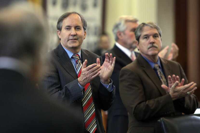 State Senators Ken Paxton, R-Collin, and Larry Taylor, R-Galveston, applaud during the...
