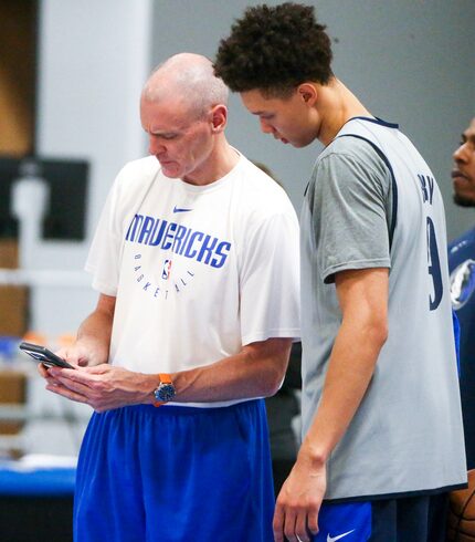 Mavericks coach Rick Carlisle shows Isaiah Roby (9) a video during a summer League practice...