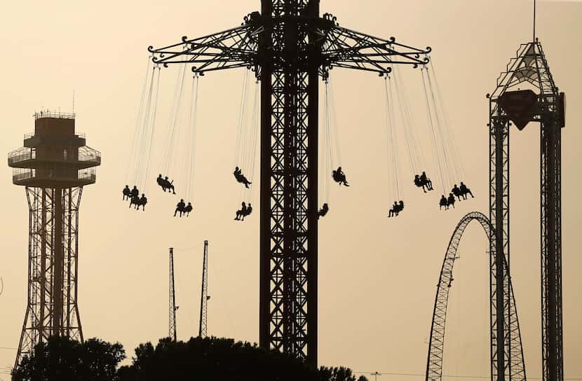 Six Flags Over Texas visitors ride the Texas SkyScreamer swing carousel ride, as Saharan...