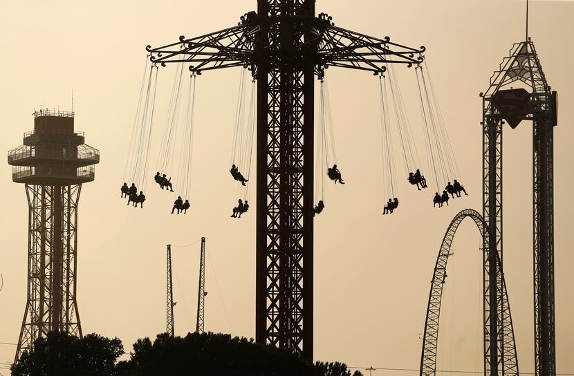 Six Flags Over Texas visitors ride the Texas SkyScreamer swing carousel ride, as Saharan...