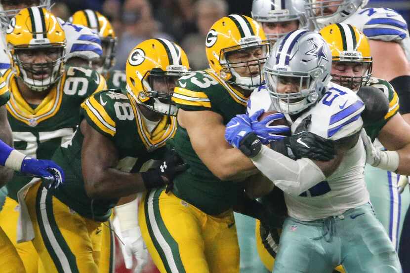 a host of Packers defenders stop Dallas Cowboys running back Ezekiel Elliott (21) in the...
