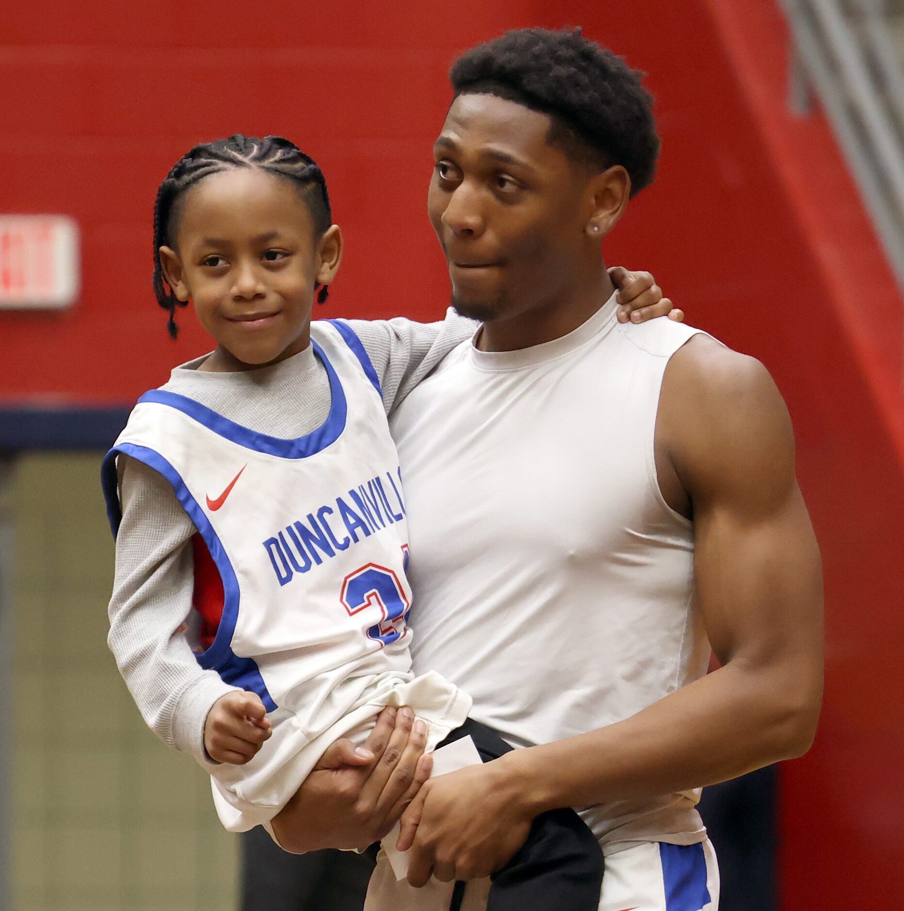 Duncanville Panthers forward Anthony Cook (24) carries his brother Ethan,5, to mid-court...