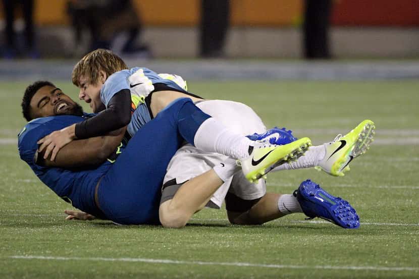 NFC running back Ezekiel Elliot of the Dallas Cowboys, tackles a man that ran on the field,...